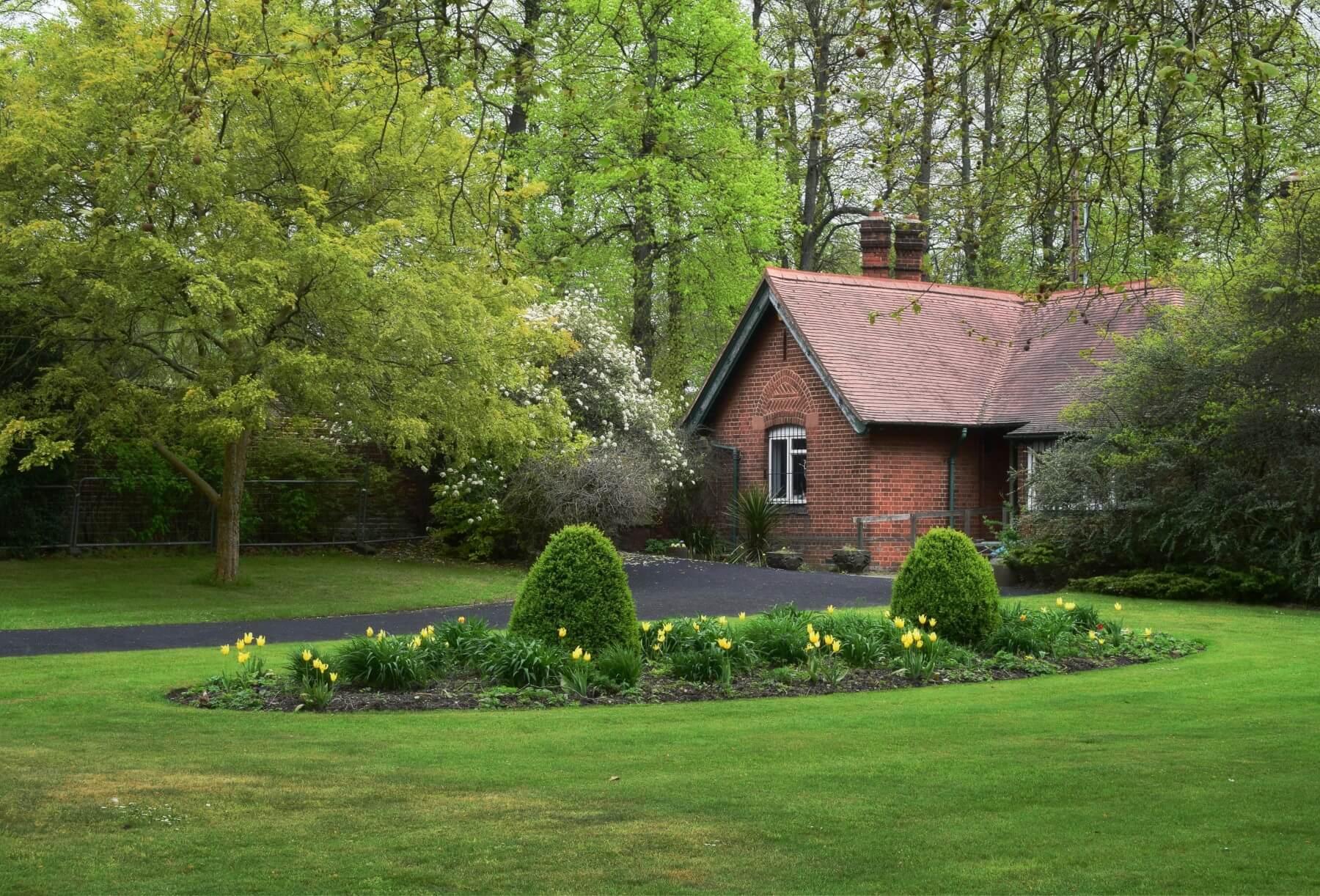 Spring planting beside a brick cottage with tulips